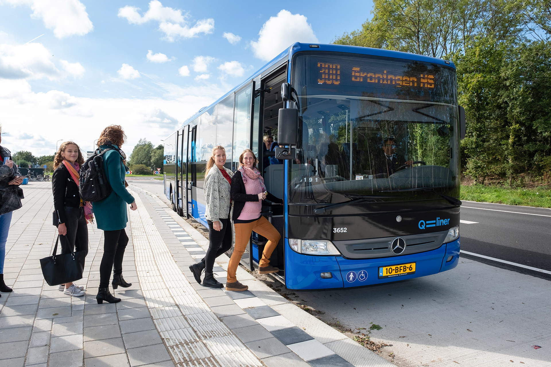 Een groepje reizigers stapt in Groningen op de bus