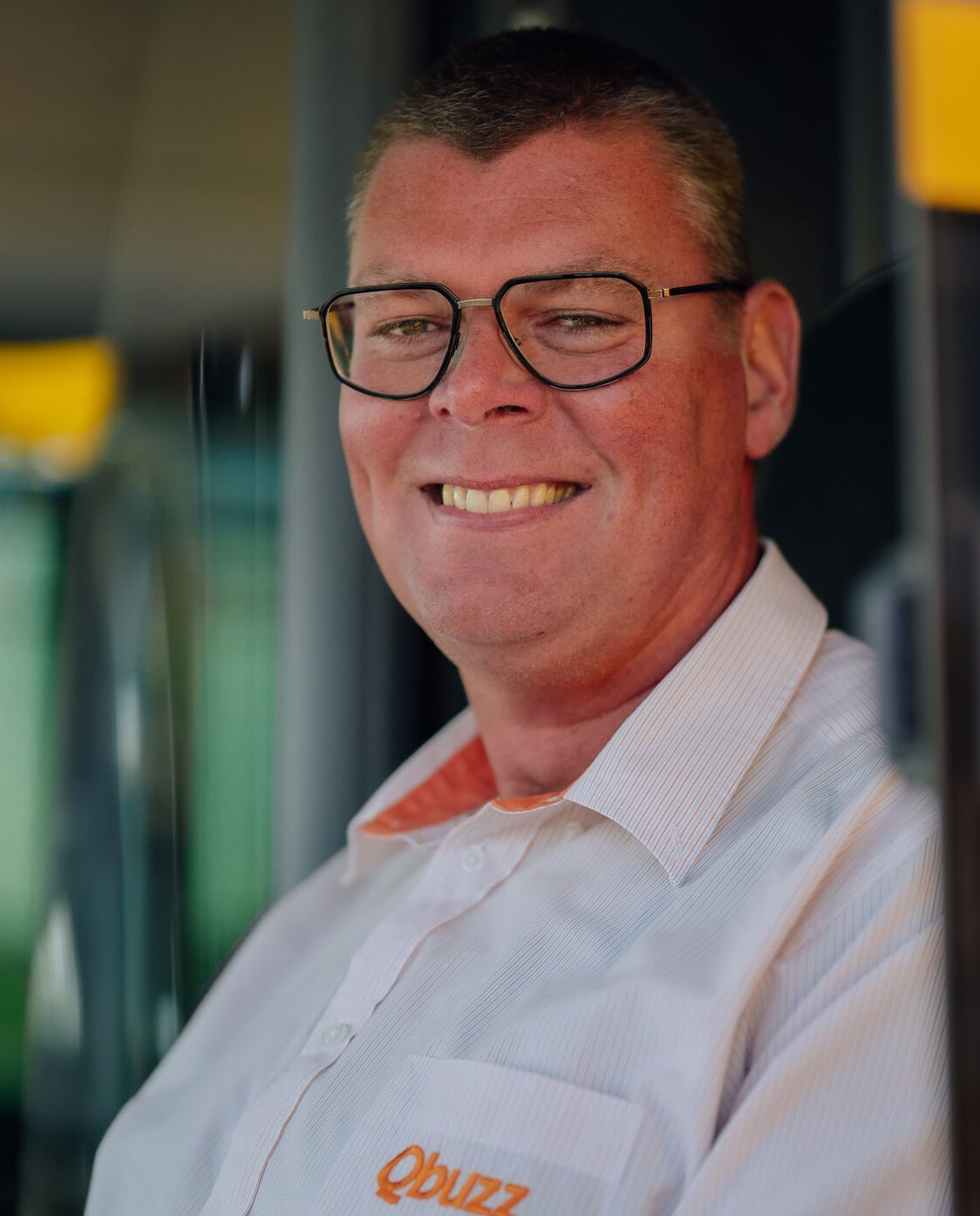 Mannelijk chauffeur kijkt glimlachend uit het raam
